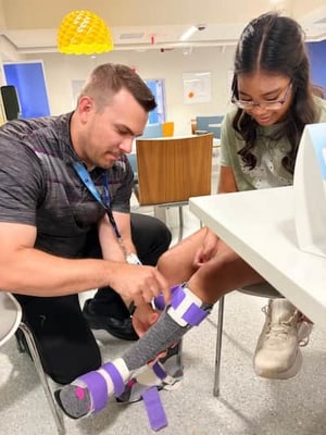 Karli getting leg braces put on by healthcare professional