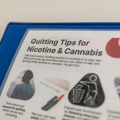 Signage entitled Quitting Tips for Nicotine & Cannabis which is on the wall of an exam room.
