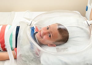 A child is testing with a clear helmet in the Kidney Center at Children's Mercy.
