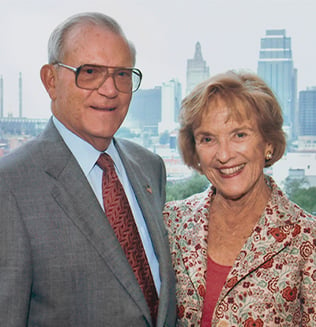 Don and Adele Hall smiling with the the Kansas City skyline in back of them.
