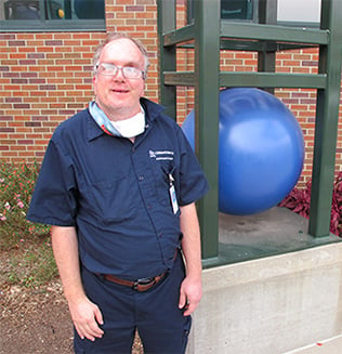 Garrett Jordan, Environmental Services Technician, smiling outside of Children's Mercy Adele Hall.