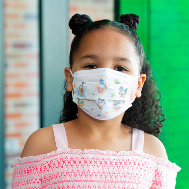 Girl wearing face mask with Disney characters on it