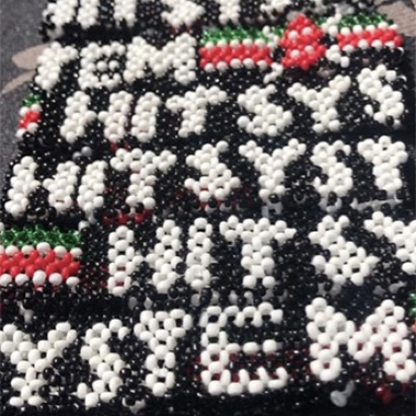 Black and white beads that spell out "HITSYSTEM"