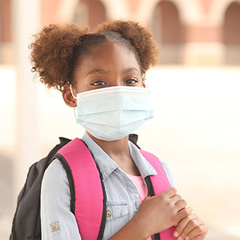 Girl with face mask wearing a backpack