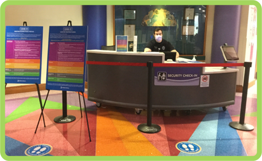 Man in face mask setting behind security desk