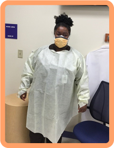 Staff member in yellow gown and face mask