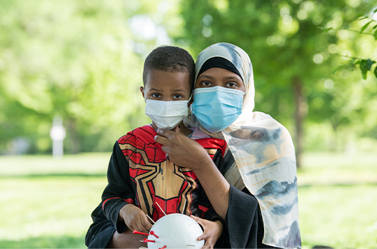 Mother and child wearing face masks looking at the camera.