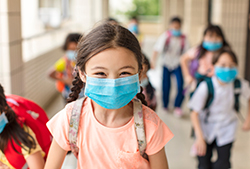 child at school outside with mask