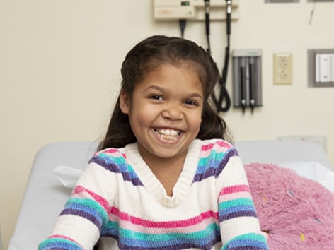 Girl smiling on hospital bed