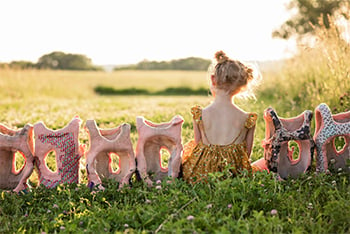 Quinn Liberman sitting with back to camera and sitting in between back braces in a grassy field