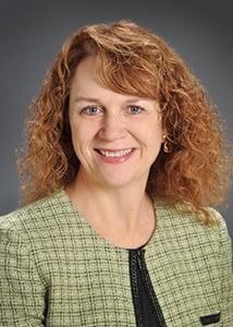 Dr. Jeanne James wearing a green blazer and smiling.