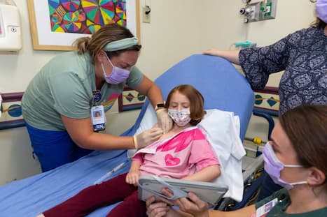 Nurse accessing port with gloved fingers.