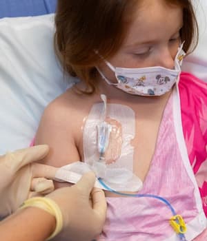 nurse placing sterile stickers over port to keep area clean.